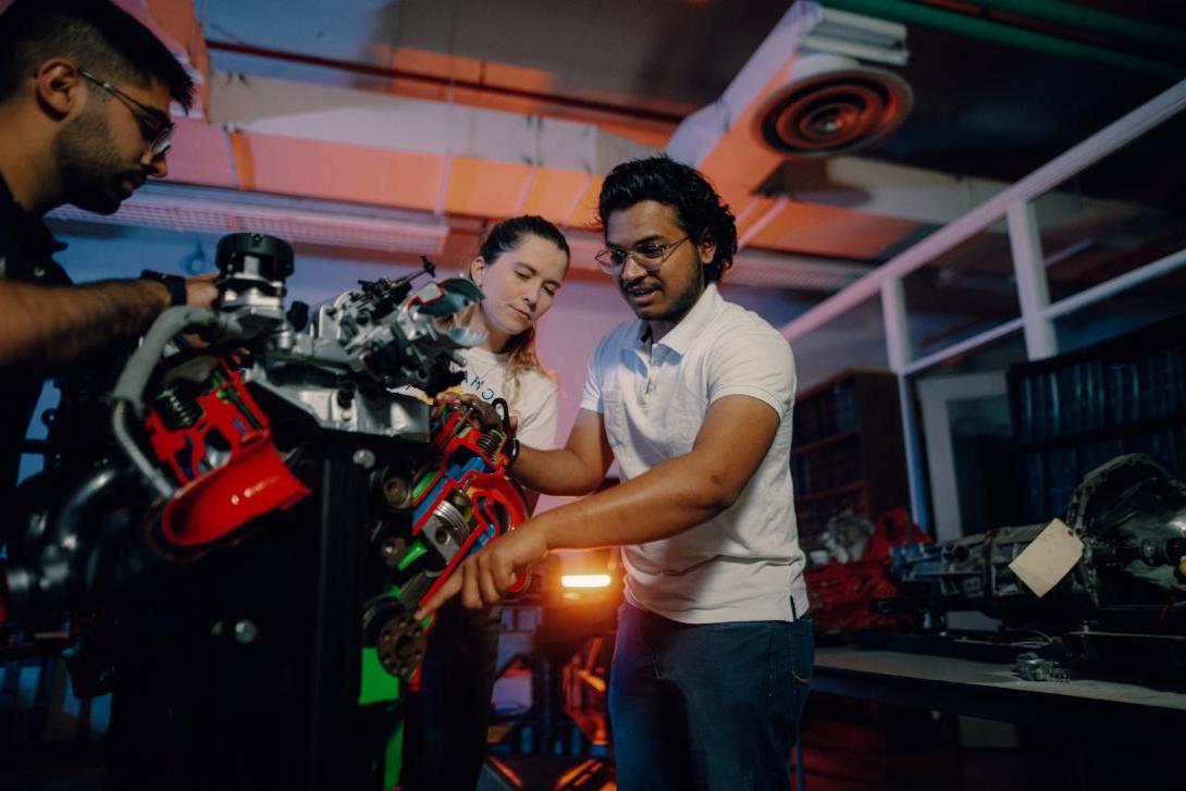 students working on car engine in lab